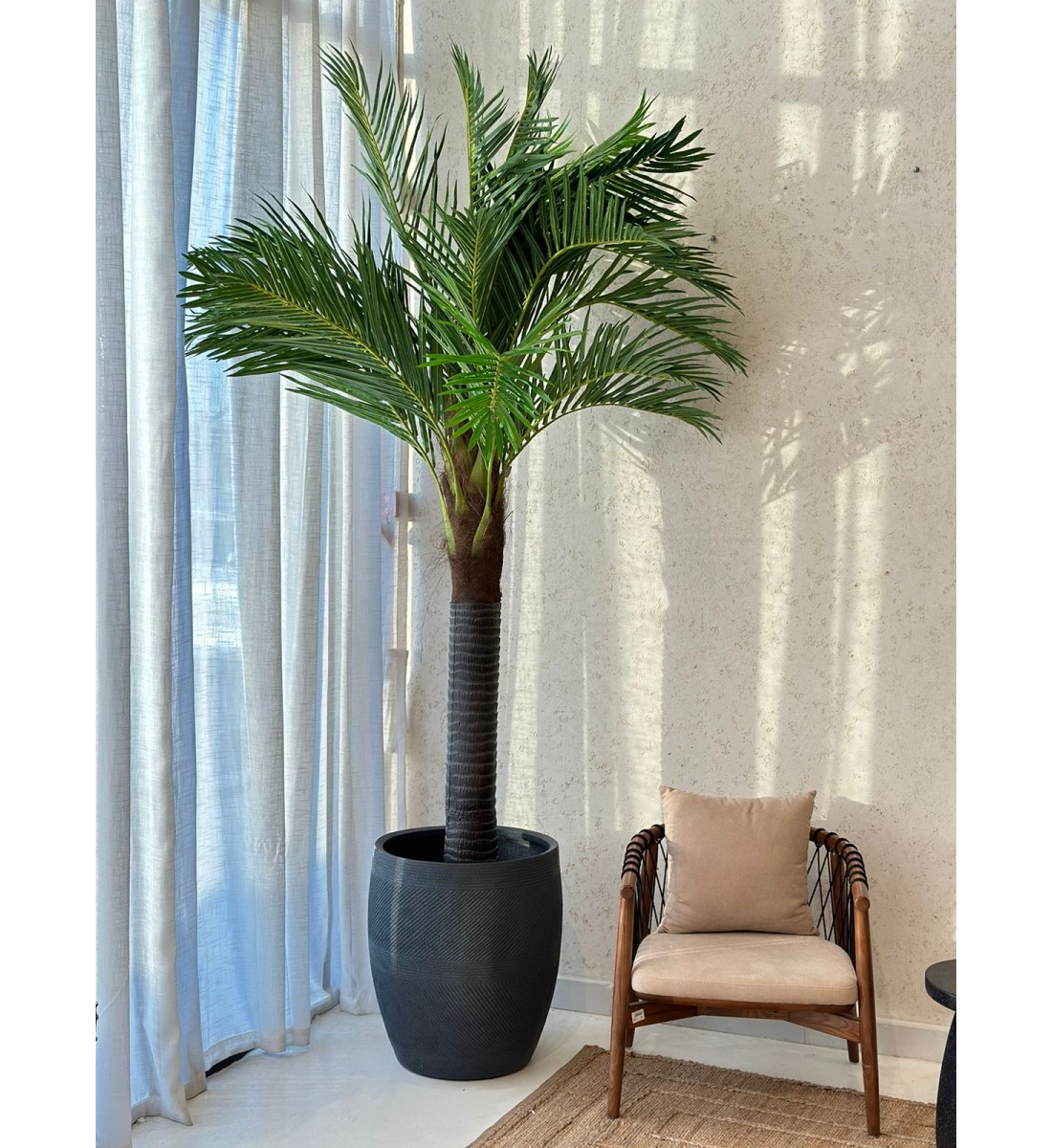 A tree decorated with palm leaves, a black stand, approximately 3 cm high