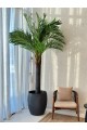 A tree decorated with palm leaves, a black stand, approximately 3 cm high