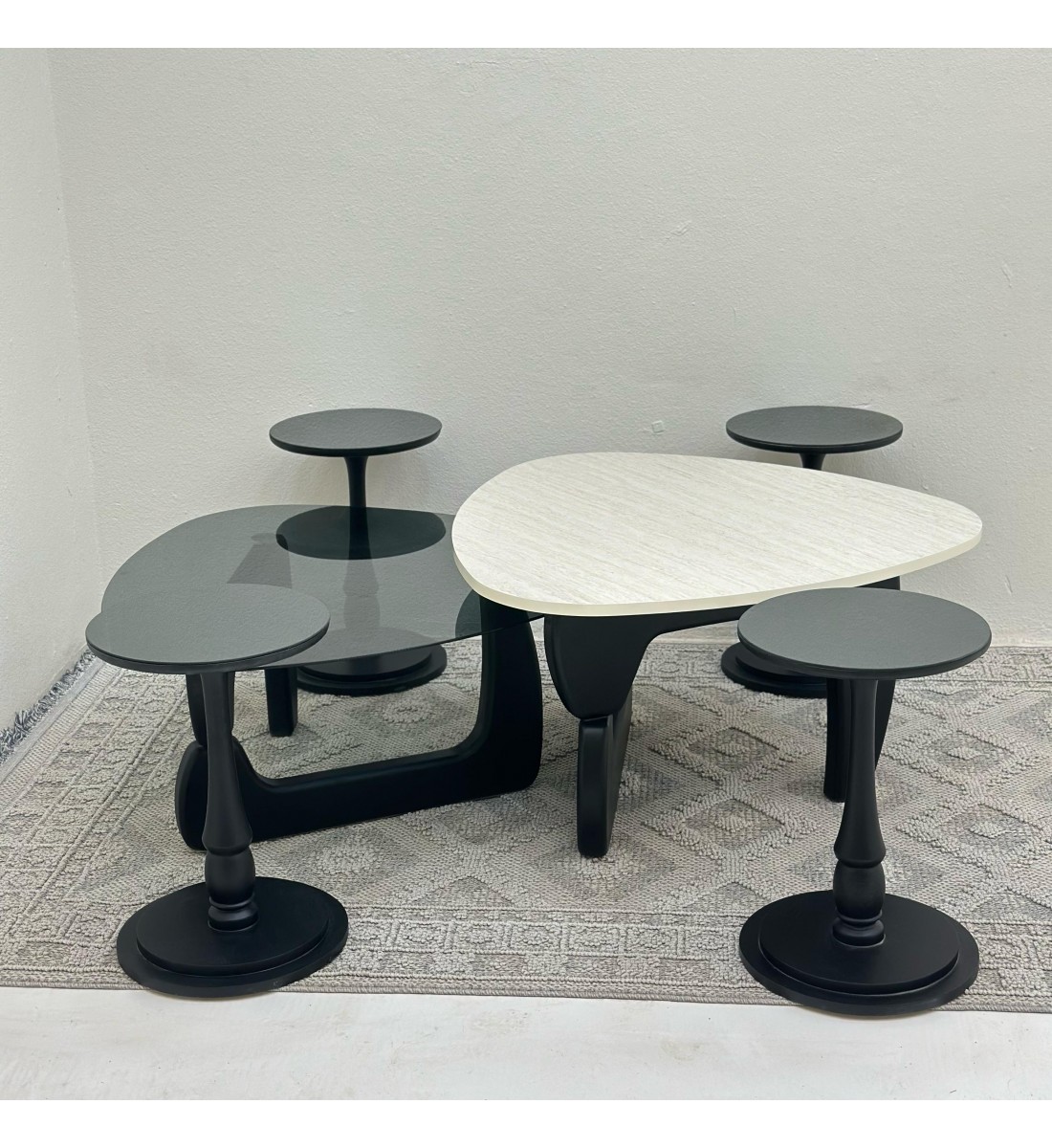 6-piece table set, the first table top is a marble alternative with a smooth texture, and the second table top is glass with black wooden bases.