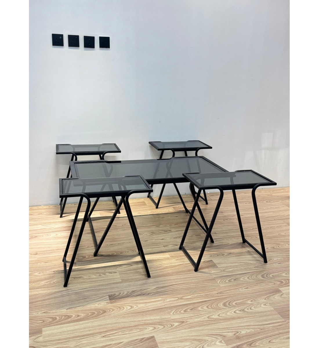 طقم متكامل من خمس طاولات بسطح زجاجي شفاف مائل للدخاني، مع هيكل معدني أسود يمنحها صلابة وأناقة في آن واحد 5قطع طقم متكامل من خمس طاولات بسطح زجاجي شفاف مائل للدخاني، مع هيكل معدني أسود يمنحها صلابة وأناقة في آن واحد 5قطع
