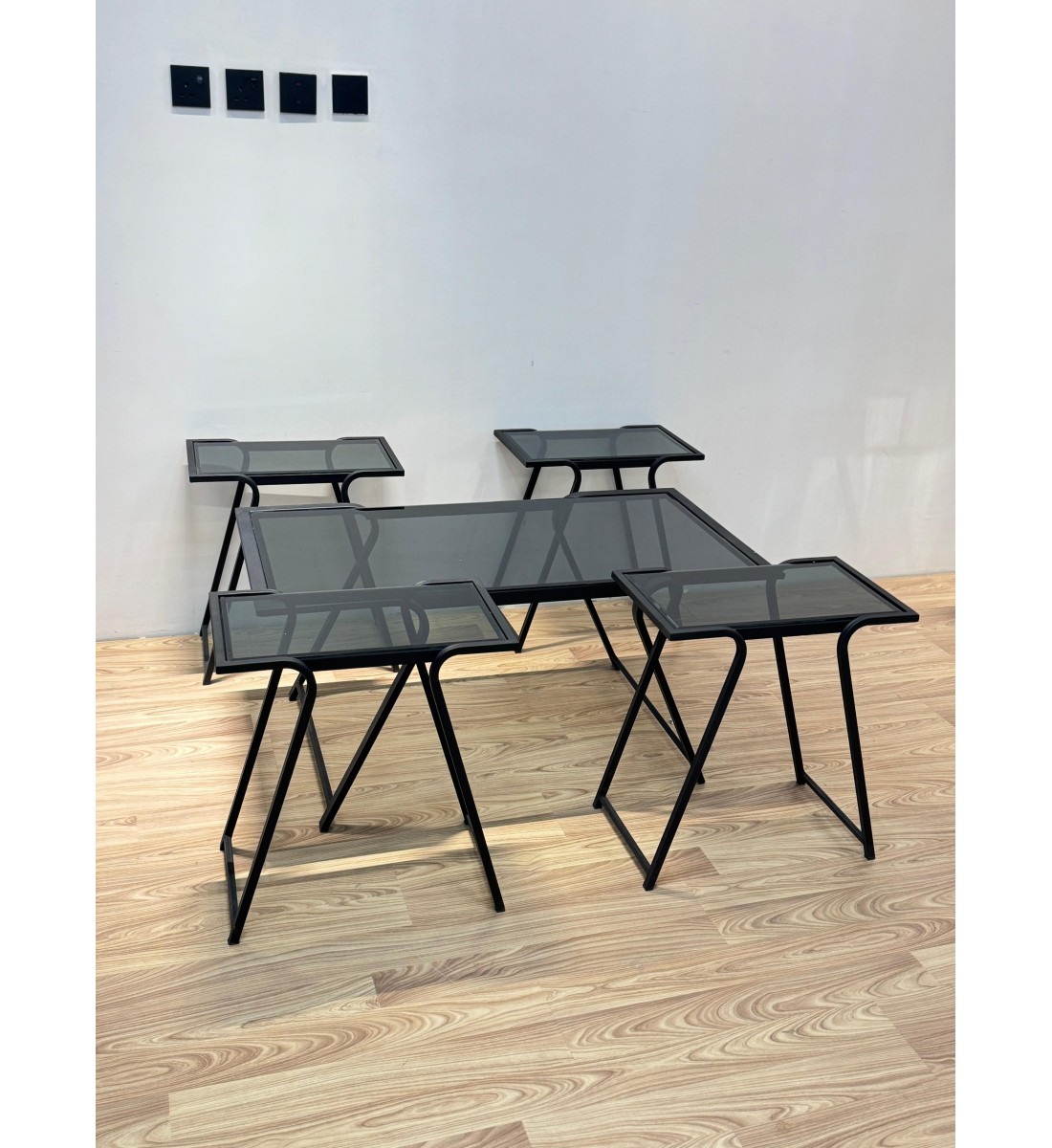 طقم متكامل من خمس طاولات بسطح زجاجي شفاف مائل للدخاني، مع هيكل معدني أسود يمنحها صلابة وأناقة في آن واحد 5قطع طقم متكامل من خمس طاولات بسطح زجاجي شفاف مائل للدخاني، مع هيكل معدني أسود يمنحها صلابة وأناقة في آن واحد 5قطع