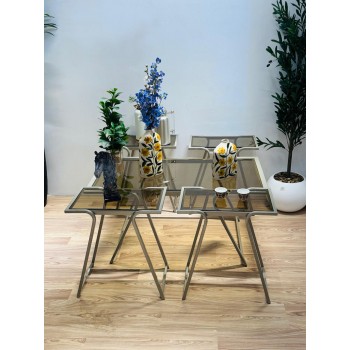 طقم متكامل من خمس طاولات بسطح زجاجي شفاف مائل للدخاني، مع هيكل معدني ذهبي فاتح يمنحها صلابة وأناقة في آن واحد 5قطع