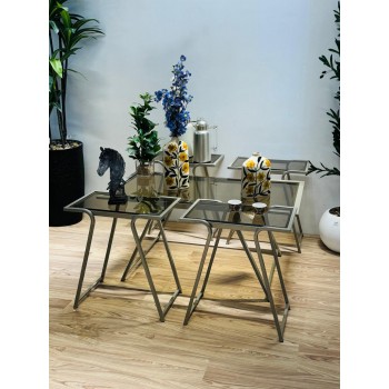 طقم متكامل من خمس طاولات بسطح زجاجي شفاف مائل للدخاني، مع هيكل معدني ذهبي فاتح يمنحها صلابة وأناقة في آن واحد 5قطع