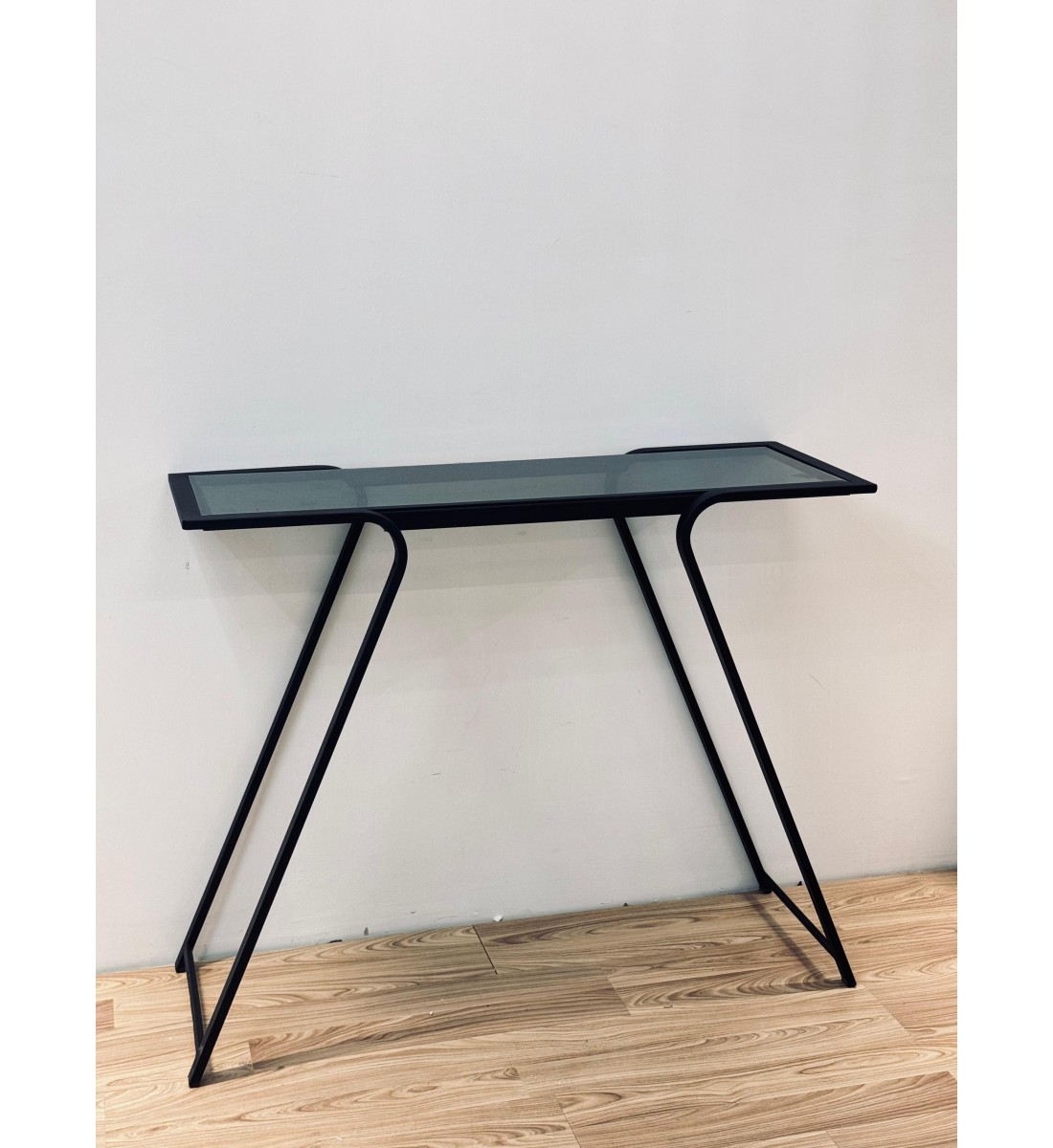 طاولة مدخل عصرية بتصميم انسيابي يجمع بين الزجاج الشفاف المائل للدخاني والإطار المعدني الأسود المتين 110×34×90سم طاولة مدخل عصرية بتصميم انسيابي يجمع بين الزجاج الشفاف المائل للدخاني والإطار المعدني الأسود المتين 110×34×90سم