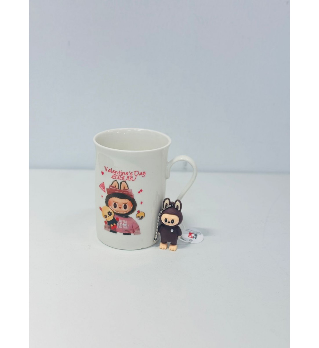 كوب شخصية كرومي تحمل دميتها اللون الابيض والوردي  شكل ولون جديد لمحبين االقهوة الساخنة حيث ان التصميم يحافظ على درجة حرارة المشروبات الساخنة