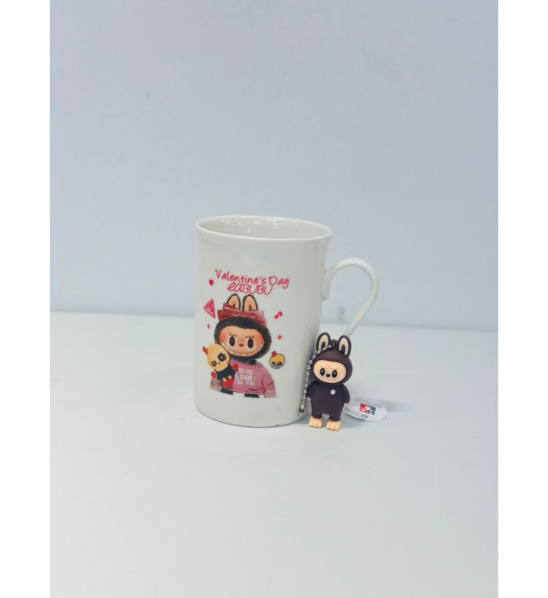 كوب شخصية كرومي تحمل دميتها اللون الابيض والوردي  شكل ولون جديد لمحبين االقهوة الساخنة حيث ان التصميم يحافظ على درجة حرارة المشروبات الساخنة