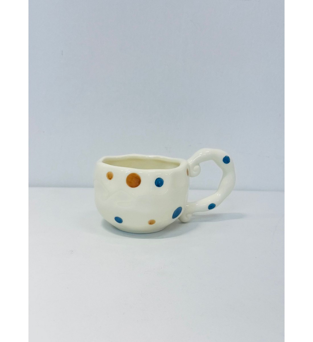 كوب خزفي بلون أبيض عاجي ناعم، منفط الازرق والبني