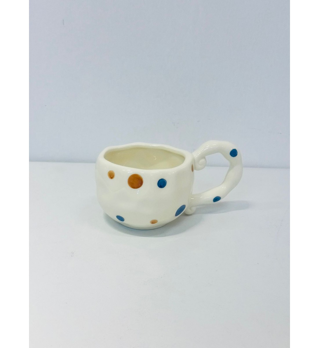 كوب خزفي بلون أبيض عاجي ناعم، منفط الازرق والبني