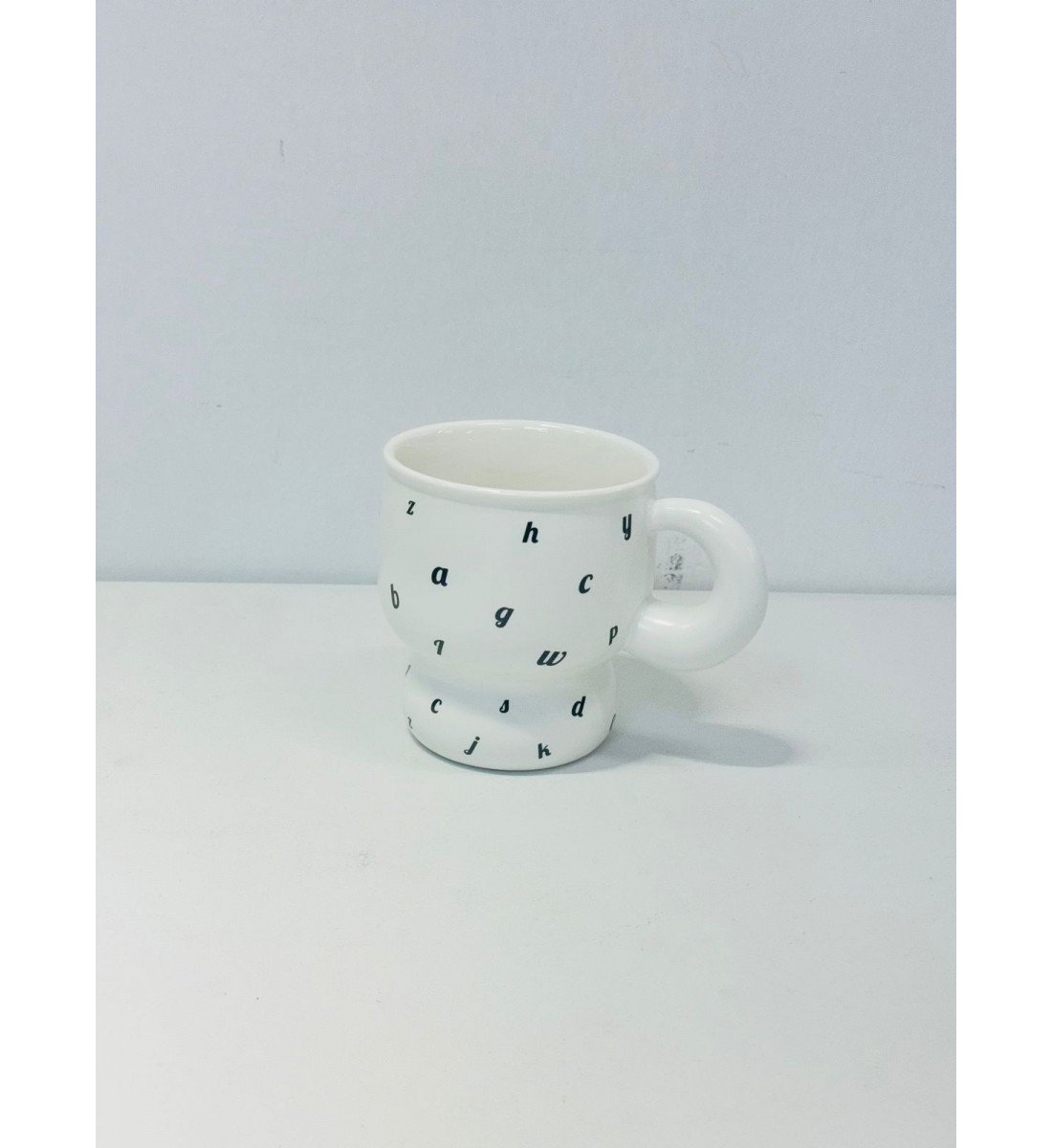 كوب خزفي بلون الابيض ناعم، مورد بالاحرف الاسود كوب خزفي بلون الابيض ناعم، مورد بالاحرف الاسود