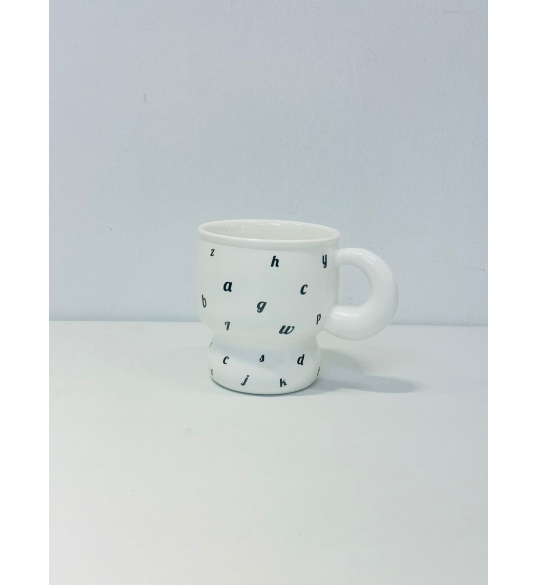 كوب خزفي بلون الابيض ناعم، مورد بالاحرف الاسود كوب خزفي بلون الابيض ناعم، مورد بالاحرف الاسود