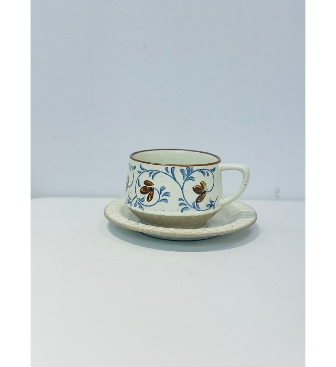 الطقم باللون العاجي الفاتح مع زخارف نباتية أنيقة تجمع بين أوراق وزهور صغيرة باللون الأزرق الهادئ والبني الدافئ الطقم باللون العاجي الفاتح مع زخارف نباتية أنيقة تجمع بين أوراق وزهور صغيرة باللون الأزرق الهادئ والبني الدافئ