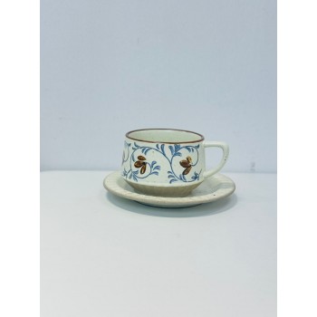 الطقم باللون العاجي الفاتح مع زخارف نباتية أنيقة تجمع بين أوراق وزهور صغيرة باللون الأزرق الهادئ والبني الدافئ