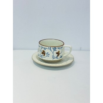 الطقم باللون العاجي الفاتح مع زخارف نباتية أنيقة تجمع بين أوراق وزهور صغيرة باللون الأزرق الهادئ والبني الدافئ