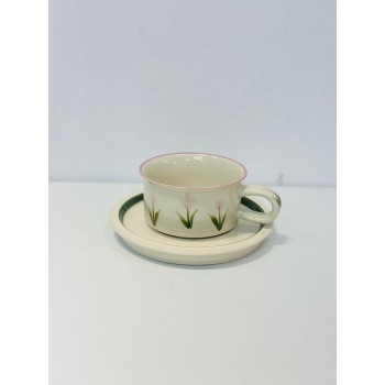 هذا طقم راقٍ مكوّن من فنجان وصحن خزفي بتصميم بسيط وأنيق. يأتي باللون العاجي الفاتح مع لمسات من الزهور الوردية الفاتحة المرسومة