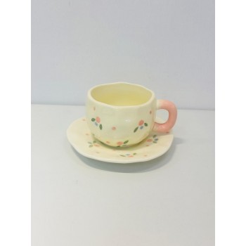 هذا طقم خزفي جميل مكوّن من فنجان وصحن بتصميم ناعم ومرح يأتي باللون الكريمي الفاتح مع رسومات صغيرة لزهور متناثرة بألوان وردي، أزرق، وأخضر 