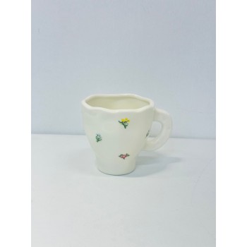 هذا كوب سيراميك أنيق باللون الأبيض العاجي، يتميز بتصميم مزين برسومات زهرية صغيرة بألوان الاصفر الازرق