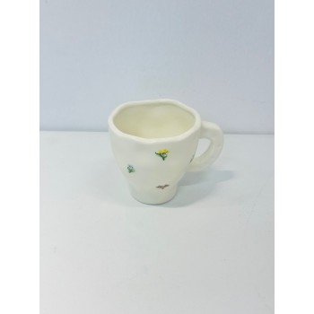 هذا كوب سيراميك أنيق باللون الأبيض العاجي، يتميز بتصميم مزين برسومات زهرية صغيرة بألوان الاصفر الازرق