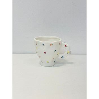 هذا كوب سيراميك أنيق باللون الأبيض العاجي، يتميز بتصميم مزين برسومات زهرية صغيرة بألوان الاصفر الازرق