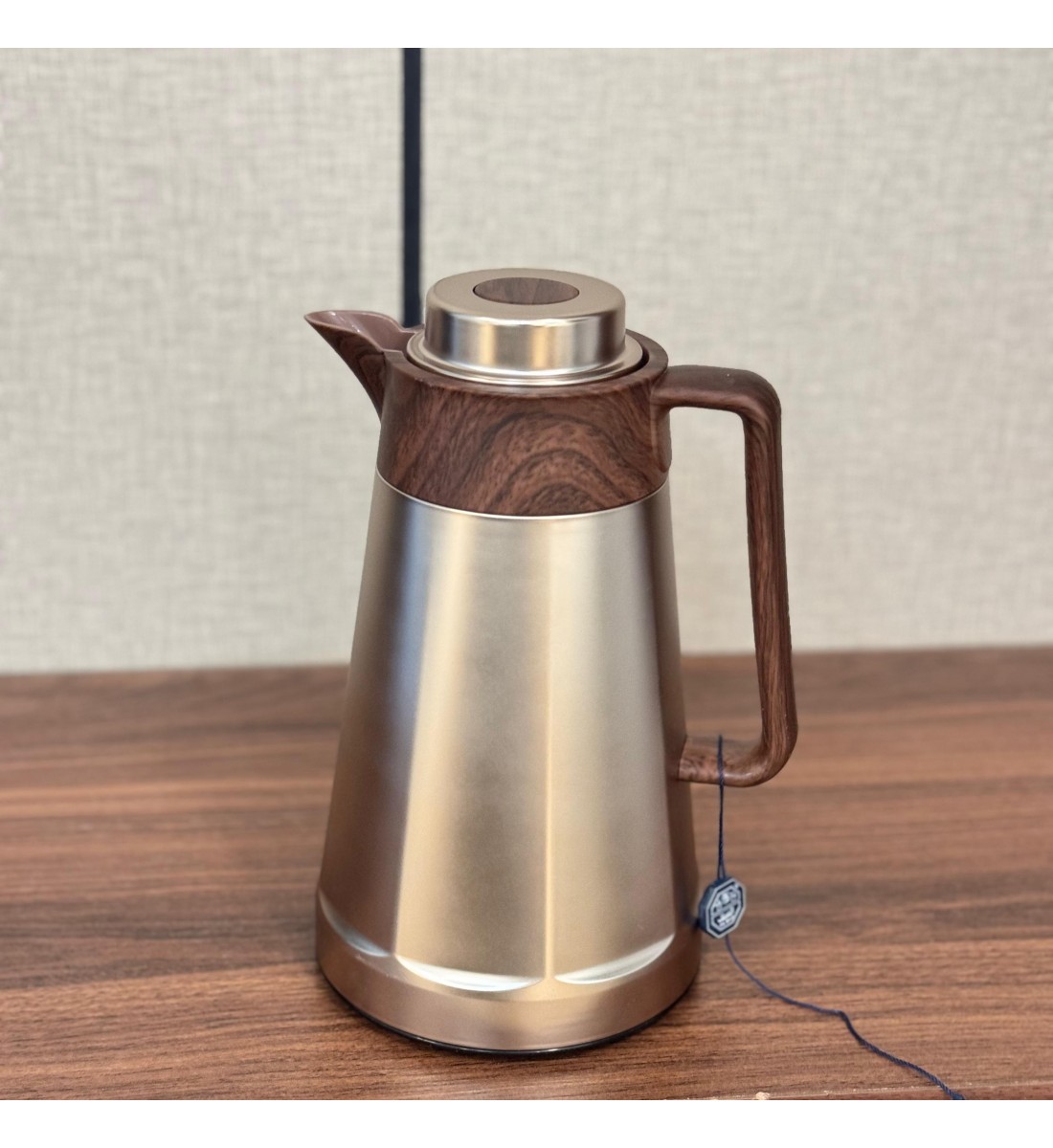 ترمس فاخر بتصميم أنيق يجمع بين المعدن اللامع باللون الذهبي المطفي وتفاصيل خشبية0.5لتر