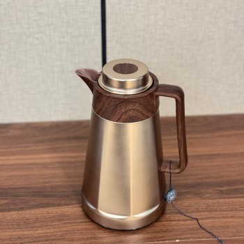 ترمس فاخر بتصميم أنيق يجمع بين المعدن اللامع باللون الذهبي المطفي وتفاصيل خشبية0.75لتر