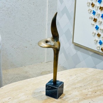 قطعة ديكورية فنية بتصميم نحتي عصري، مصنوعة بلون برونزي دافئ بلمسة أنتيك راقية، ترتكز على قاعدة مربعة من الرخام الأسود60×10×10سم 