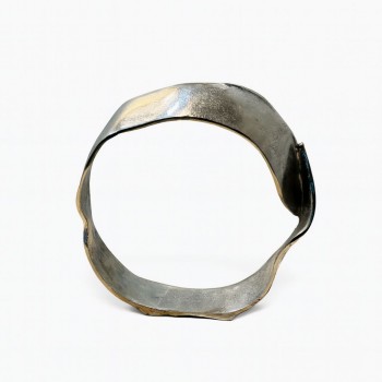 قطعة ديكور معدنية بتصميم فني معاصر، تأتي بشكل دائري غير منتظم يعكس الطابع التجريدي الحديث. مصنوعة من معدن مطفي 33×33×7سم 