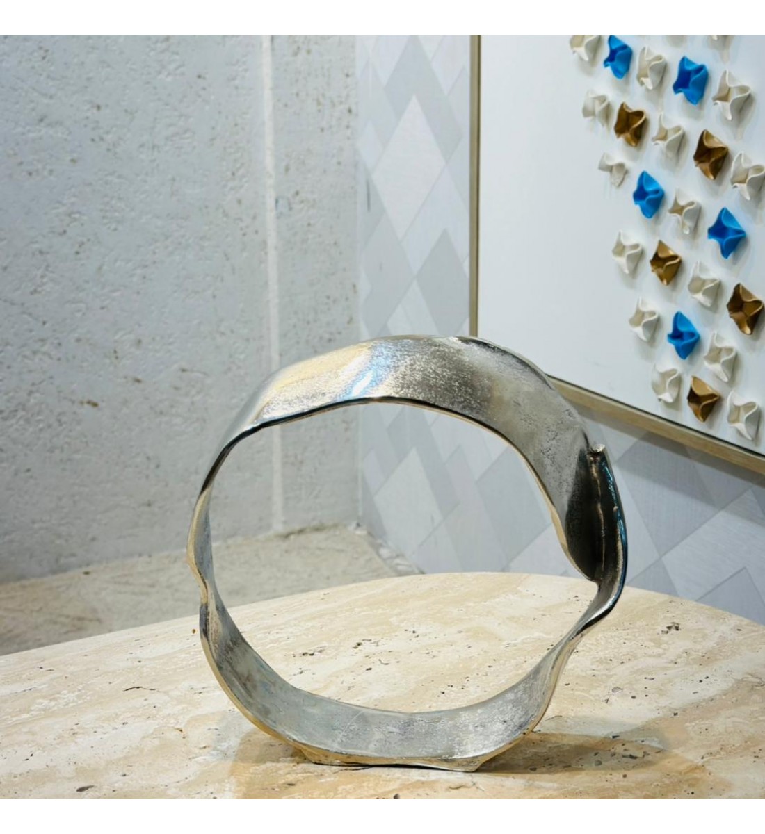 قطعة ديكور معدنية بتصميم فني معاصر، تأتي بشكل دائري غير منتظم يعكس الطابع التجريدي الحديث. مصنوعة من معدن مطفي 33×33×7سم قطعة ديكور معدنية بتصميم فني معاصر، تأتي بشكل دائري غير منتظم يعكس الطابع التجريدي الحديث. مصنوعة من معدن مطفي 33×33×7سم