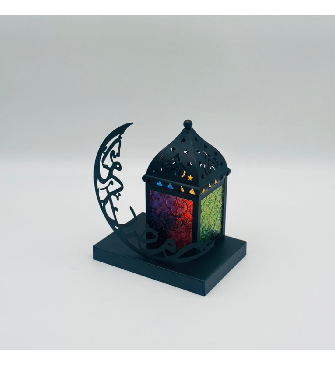 فانوس ديكوري رمضاني بتصميم عصري أنيق، مصنوع من معدن أسود فاخر مع نوافذ جانبية ملوّنة بنقوش شرقية تضفي إضاءة دافئة وجذابة فانوس ديكوري رمضاني بتصميم عصري أنيق، مصنوع من معدن أسود فاخر مع نوافذ جانبية ملوّنة بنقوش شرقية تضفي إضاءة دافئة وجذابة
