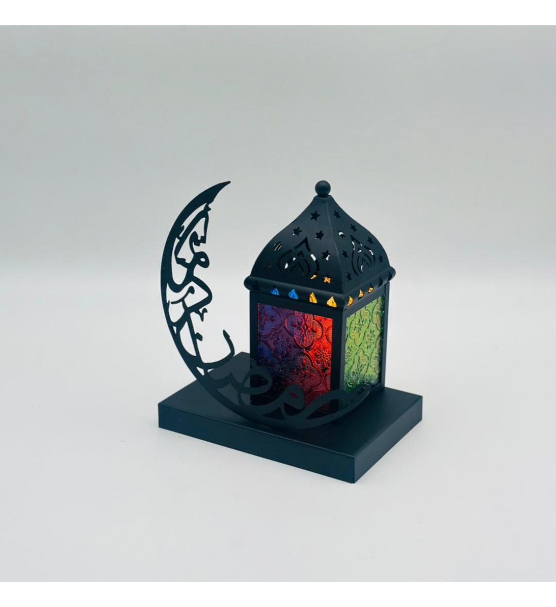 فانوس ديكوري رمضاني بتصميم عصري أنيق، مصنوع من معدن أسود فاخر مع نوافذ جانبية ملوّنة بنقوش شرقية تضفي إضاءة دافئة وجذابة فانوس ديكوري رمضاني بتصميم عصري أنيق، مصنوع من معدن أسود فاخر مع نوافذ جانبية ملوّنة بنقوش شرقية تضفي إضاءة دافئة وجذابة