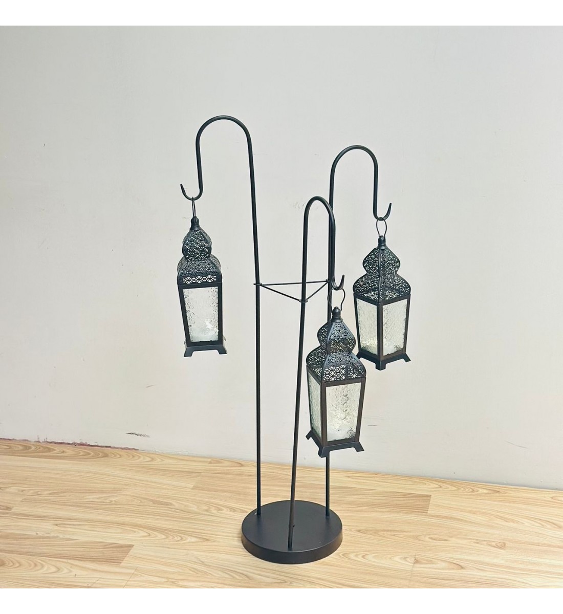 قطعة ديكورية أنيقة بتصميم عمودي مميّز، تتكوّن من حامل معدني أسود يحمل ثلاثة فوانيس معلّقة بنقوش شرقية دقيقة وزجاج يعطي إضاءة دافئة وناعمة 102×40×40سم قطعة ديكورية أنيقة بتصميم عمودي مميّز، تتكوّن من حامل معدني أسود يحمل ثلاثة فوانيس معلّقة بنقوش شرقية دقيقة وزجاج يعطي إضاءة دافئة وناعمة 102×40×40سم