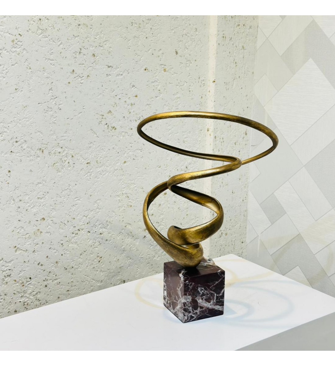 قطعة ديكور فنية بتصميم حلزوني عصري يعكس الحركة والانسيابية بأسلوب أنيق. مصنوعة من معدن ذهبي بلمسة نهائية فاخV42×30×25سم 