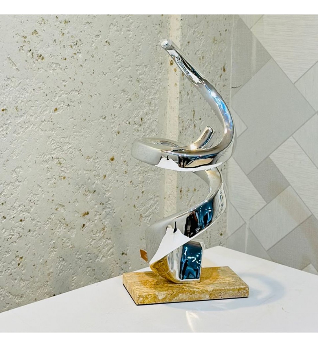 قطعة ديكور فنية بتصميم حلزوني عصري يجسّد الانسيابية والتوازن بأسلوب أنيق. مصنوعة من معدن لامع باللون الفضي40×18×10سم قطعة ديكور فنية بتصميم حلزوني عصري يجسّد الانسيابية والتوازن بأسلوب أنيق. مصنوعة من معدن لامع باللون الفضي40×18×10سم