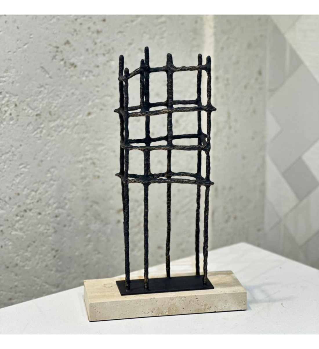  عمل فني بتصميم هندسي تجريدي يجمع بين البساطة والقوة، مصنوع من معدن داكن بخطوط عمودية 25×10×41سم 