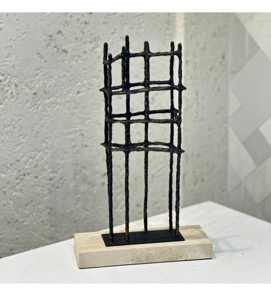  عمل فني بتصميم هندسي تجريدي يجمع بين البساطة والقوة، مصنوع من معدن داكن بخطوط عمودية 25×10×41سم 