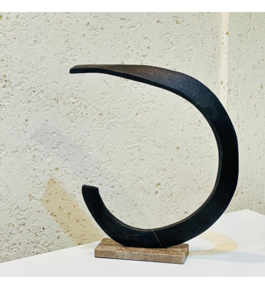 قطعة فنية أنيقة بتصميم هلالي انسيابي يعكس البساطة والهدوء، مصنوعة من معدن داكن بملمس مطفأ فاخر 42×34×8سم 