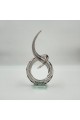 A decorative art piece made of clear glass with a streamlined design inspired by the musical note symbol, 33 x 13 x 8 cm