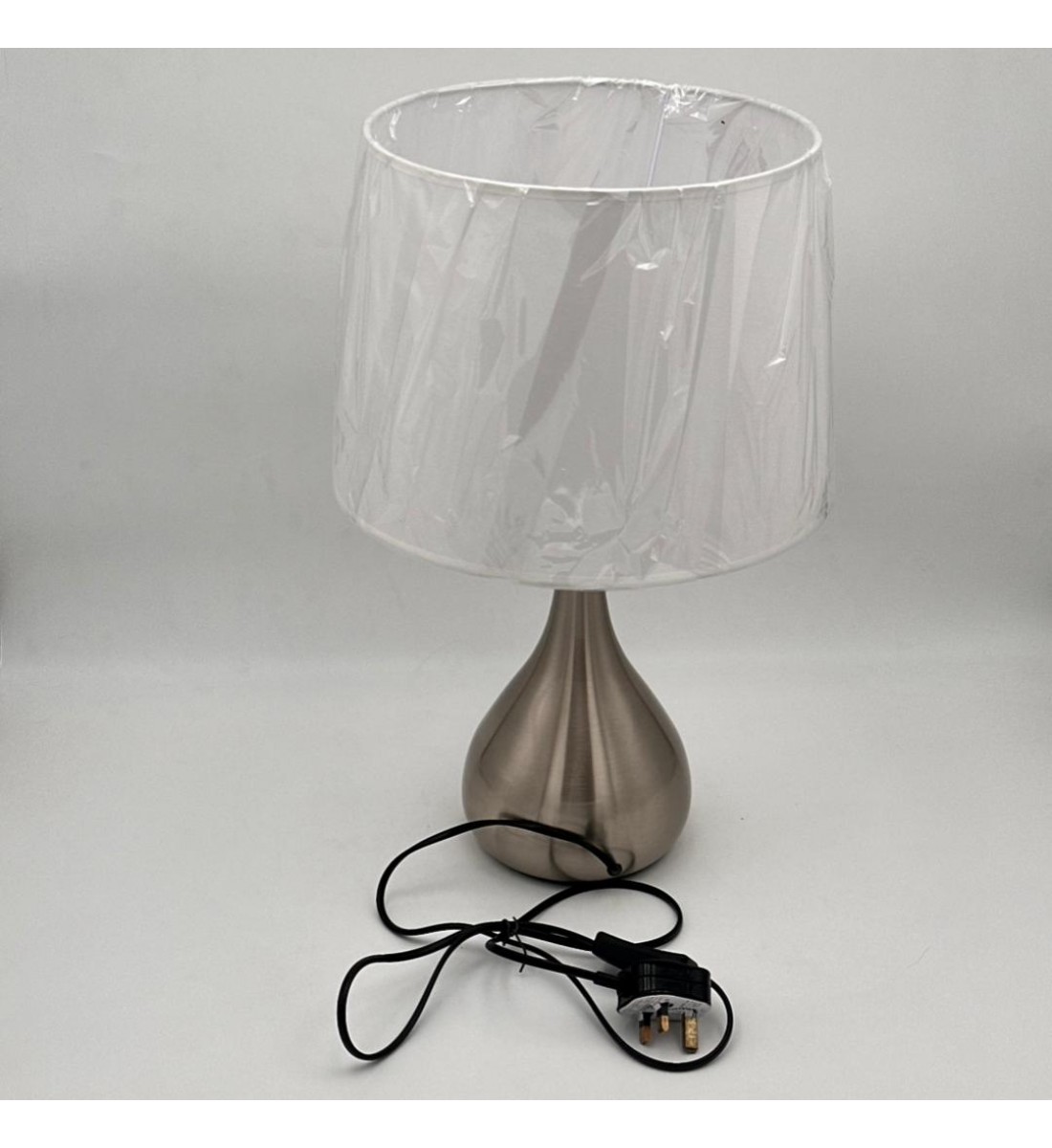 مصباح طاولة أنيق بتصميم عصري يجمع بين البساطة والفخامة، يأتي بقاعدة معدنية بلون فضي مطفي بتشكيل انسيابي أنيق،47سم 