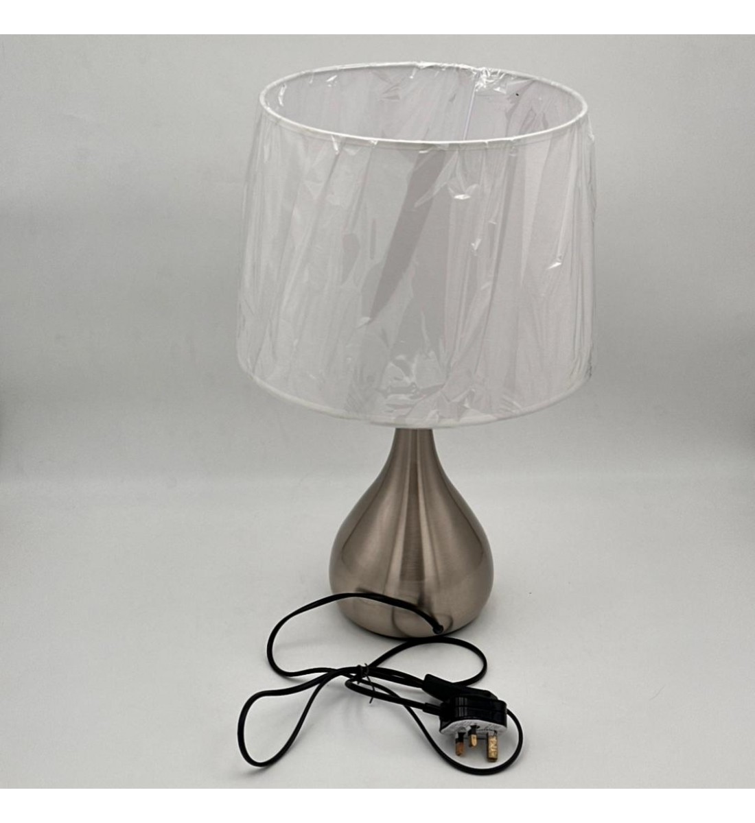 مصباح طاولة أنيق بتصميم عصري يجمع بين البساطة والفخامة، يأتي بقاعدة معدنية بلون فضي مطفي بتشكيل انسيابي أنيق،47سم 