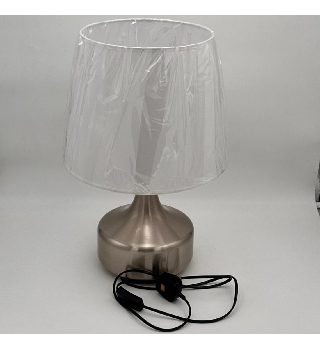 مصباح طاولة أنيق بتصميم عصري يجمع بين البساطة والفخامة، يأتي بقاعدة معدنية بلون فضي مطفي بتشكيل انسيابي أنيق،47سم 