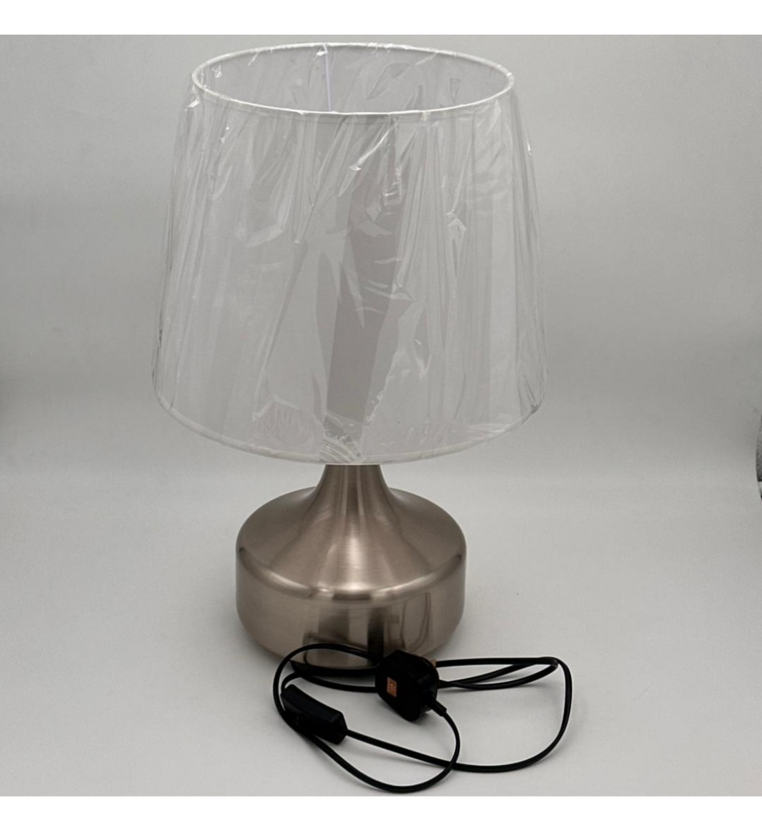 مصباح طاولة أنيق بتصميم عصري يجمع بين البساطة والفخامة، يأتي بقاعدة معدنية بلون فضي مطفي بتشكيل انسيابي أنيق،47سم 
