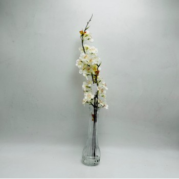 Artificial cherry blossom branches for decoration, featuring an elegant, clear glass vase. Artificial cherry blossom branches for decoration, featuring an elegant, clear glass vase.