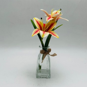 Premium artificial lily flower stems in a clear glass vase. Premium artificial lily flower stems in a clear glass vase.